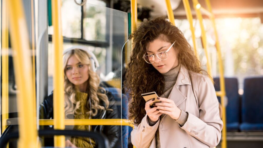 two girls riding the bus phone headphones