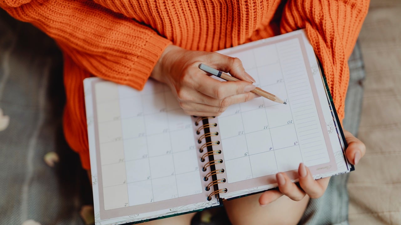 A woman filing out her planner.