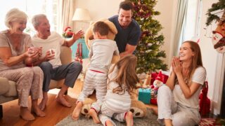 a family with three generations opens gifts on Christmas morning