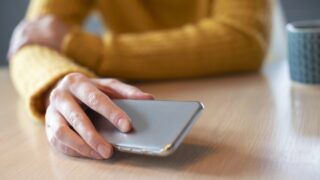 a hand sets a smartphone down on a table
