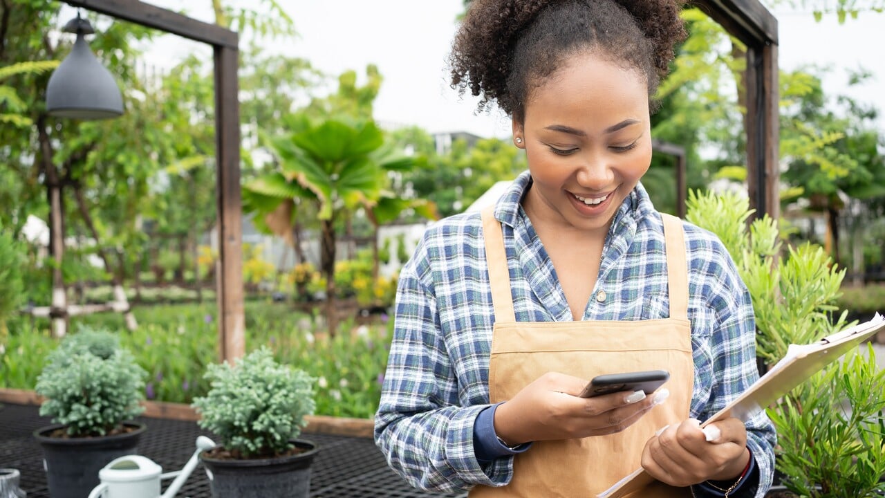 Gardener using mobile phone to texting to her family,customer.