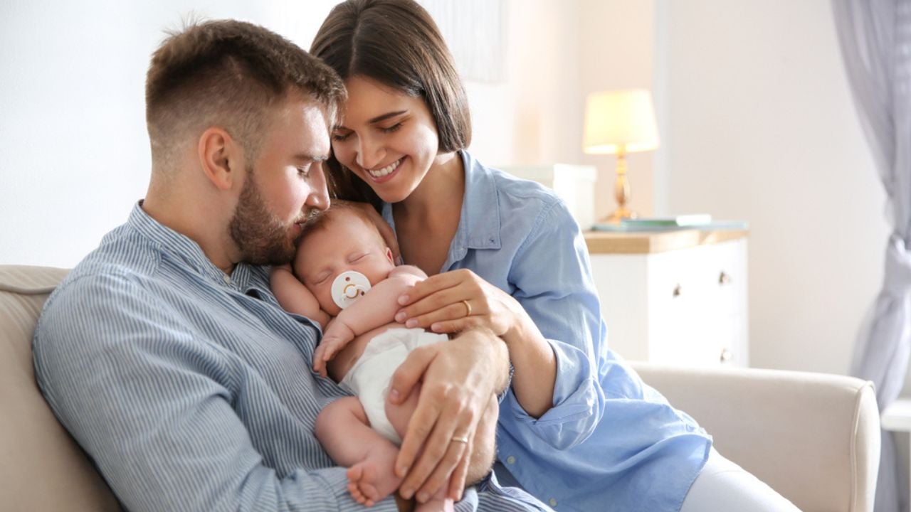 Happy Couple with Their Newborn Baby at Home