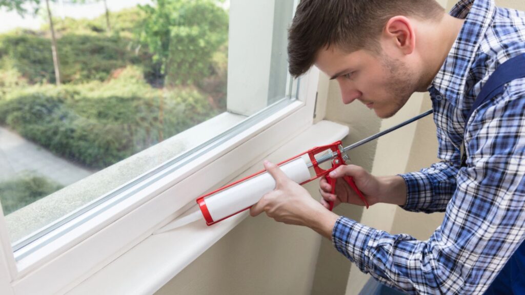 man Applying Silicone at the window