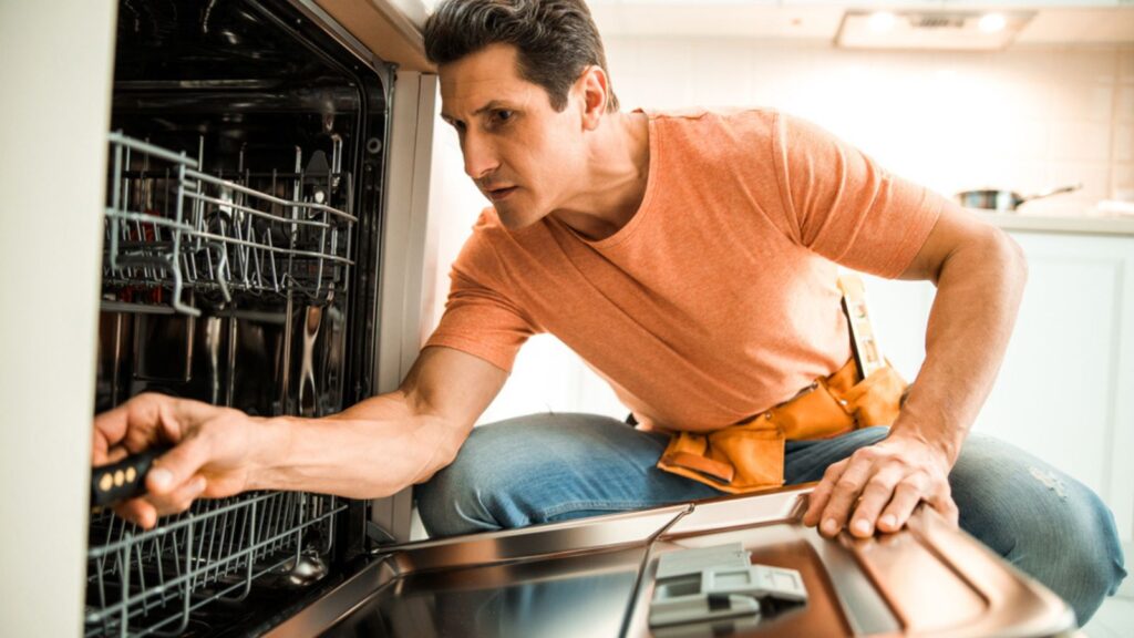 man fixing appliance dishwasher