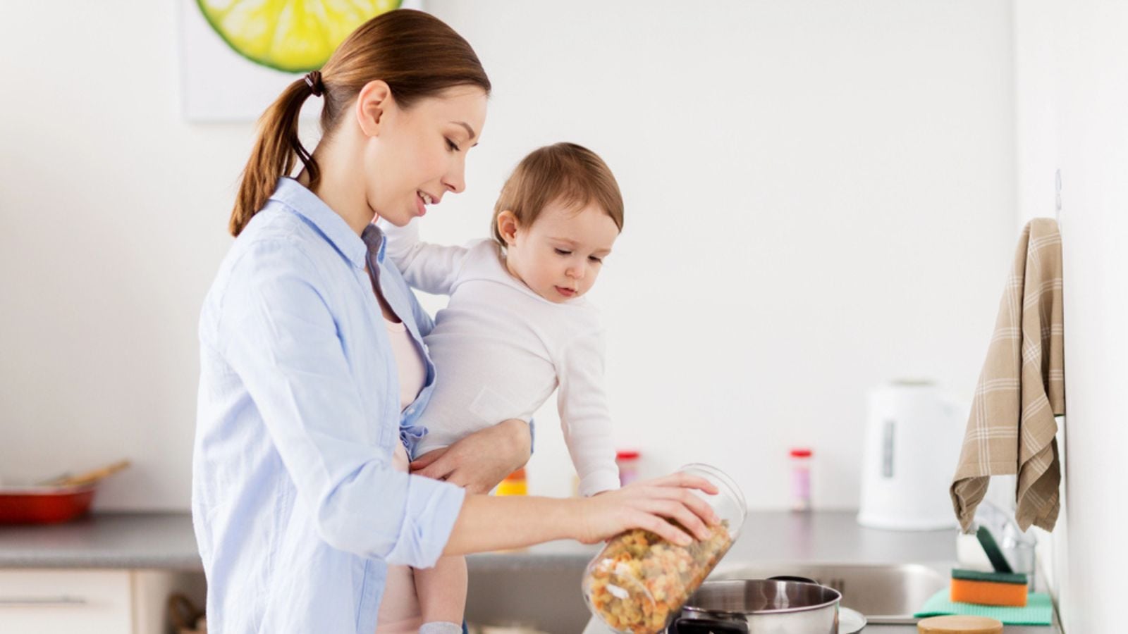 Mother and baby cooking pasta at home kitchen