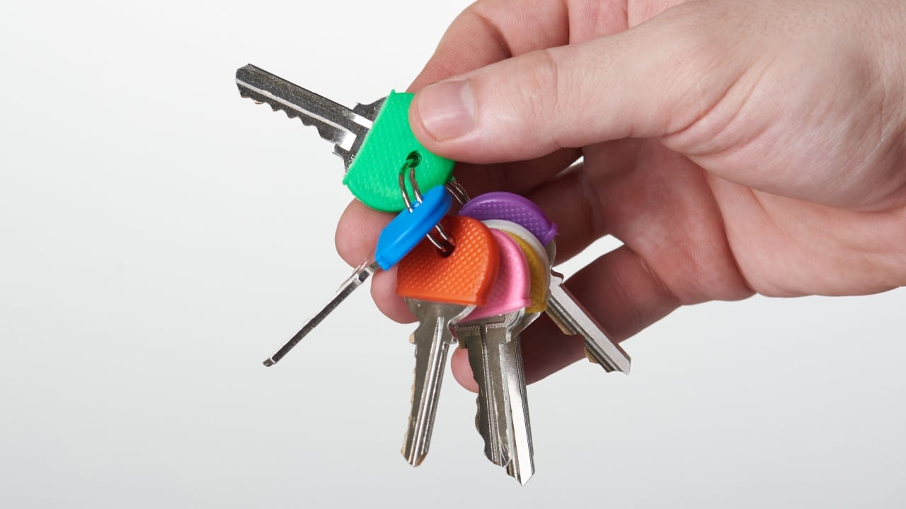 Set of colorful keys in hand close-up view isolated