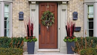 wooden front door with wreath and seasonal decorations