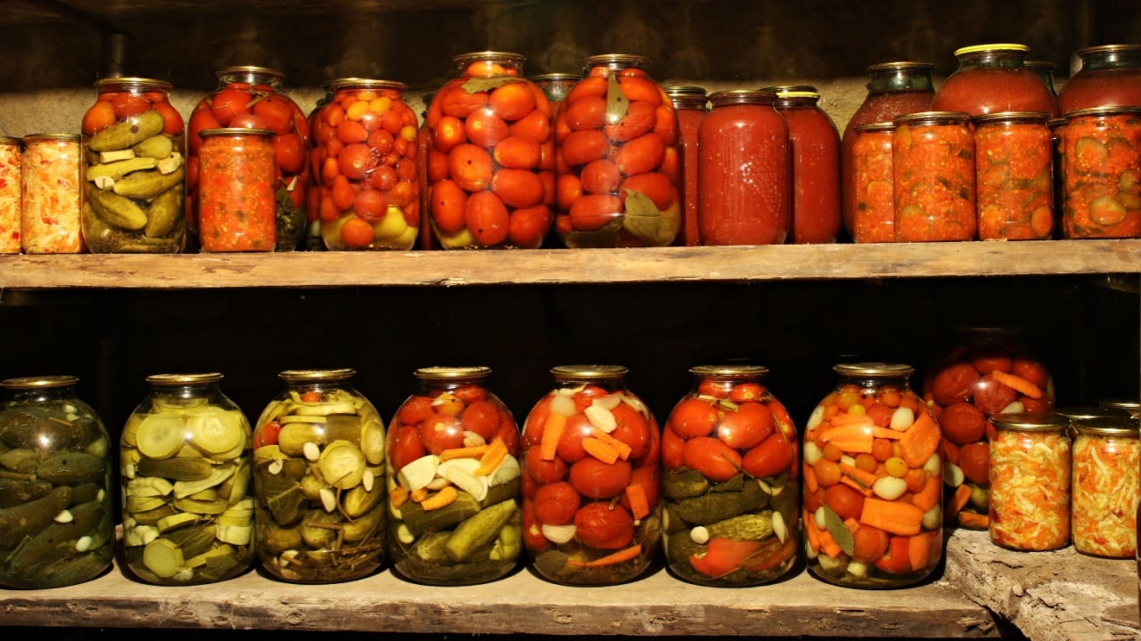Home made vegetables canned in glass jars are displayed on shelves in the basement.