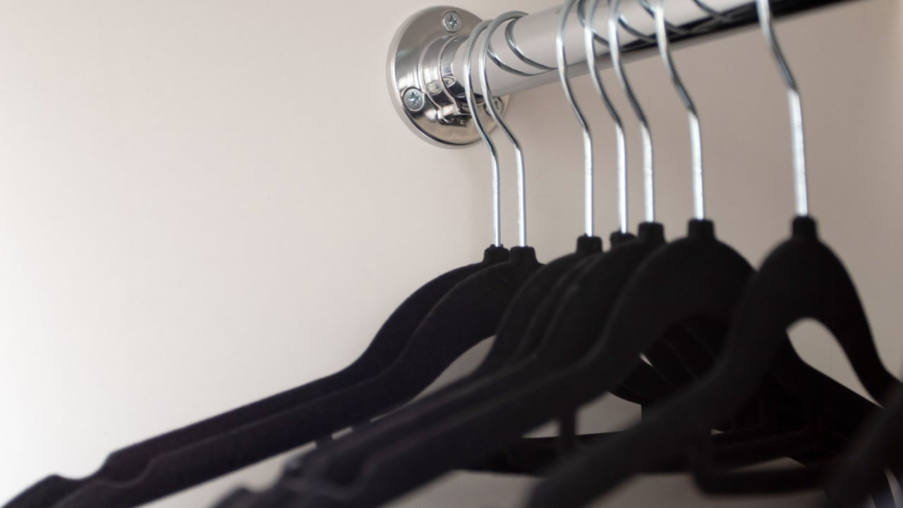 Black hangers in the closet. Hangers in the cabinet on the rod. Empty wardrobe.