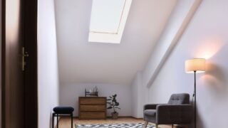 Attic room interior with slanted ceiling and furniture