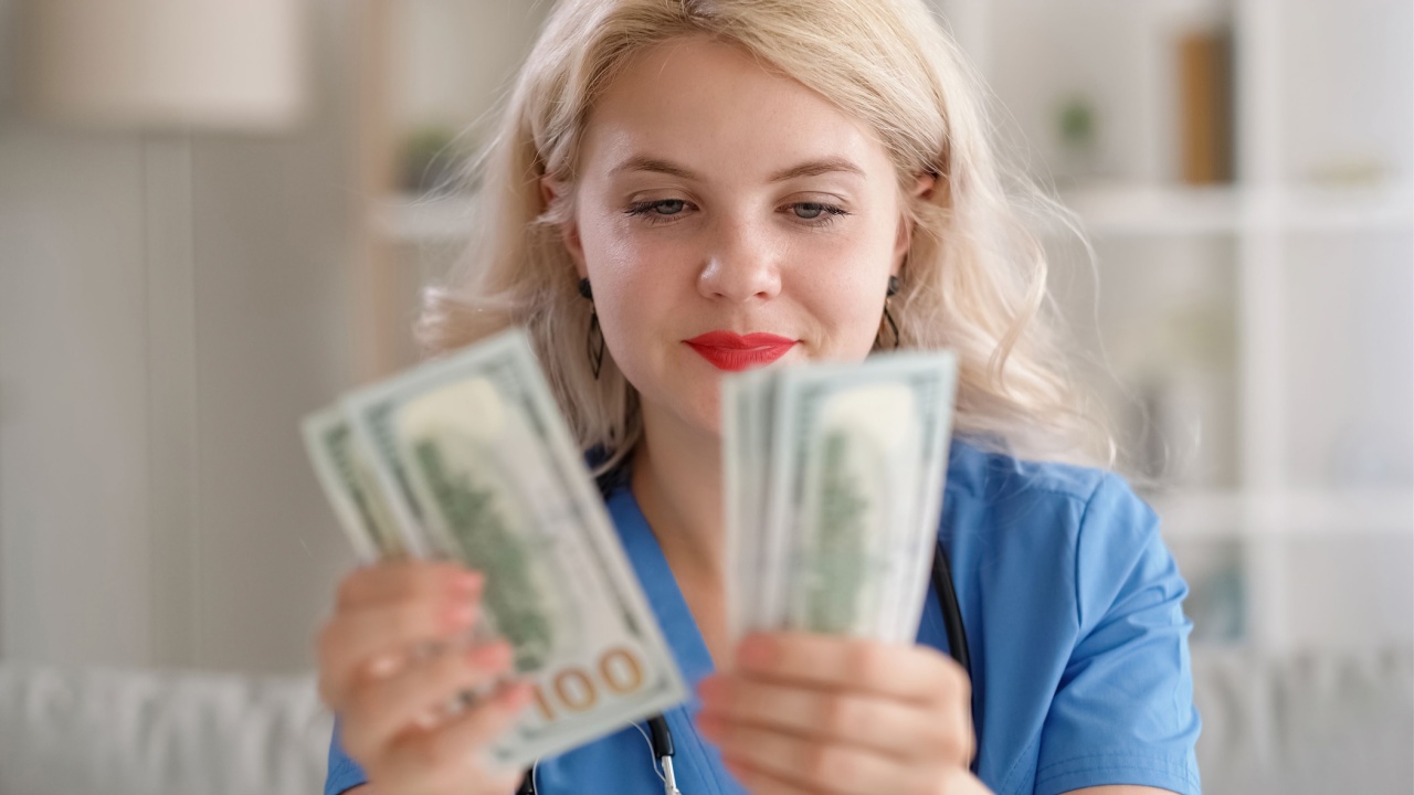 Medical corruption. Healthcare profit. Greedy rich blonde female doctor counting cash money bribe 100 bill American US dollars banknotes.