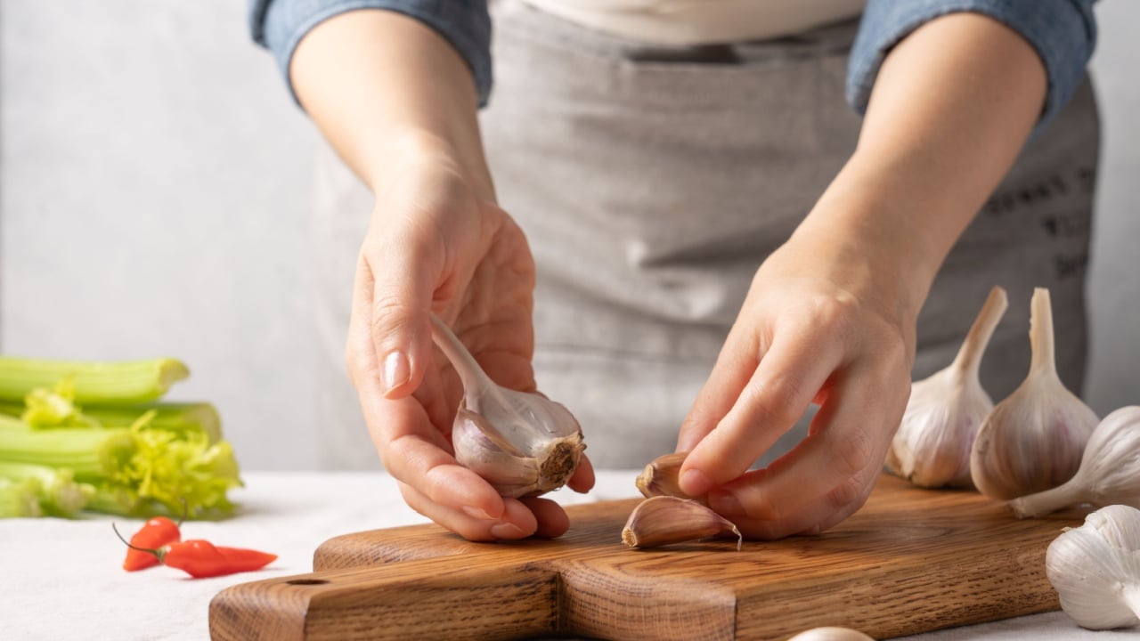 Women's hands holding garlic. Cooking homemade healthy food