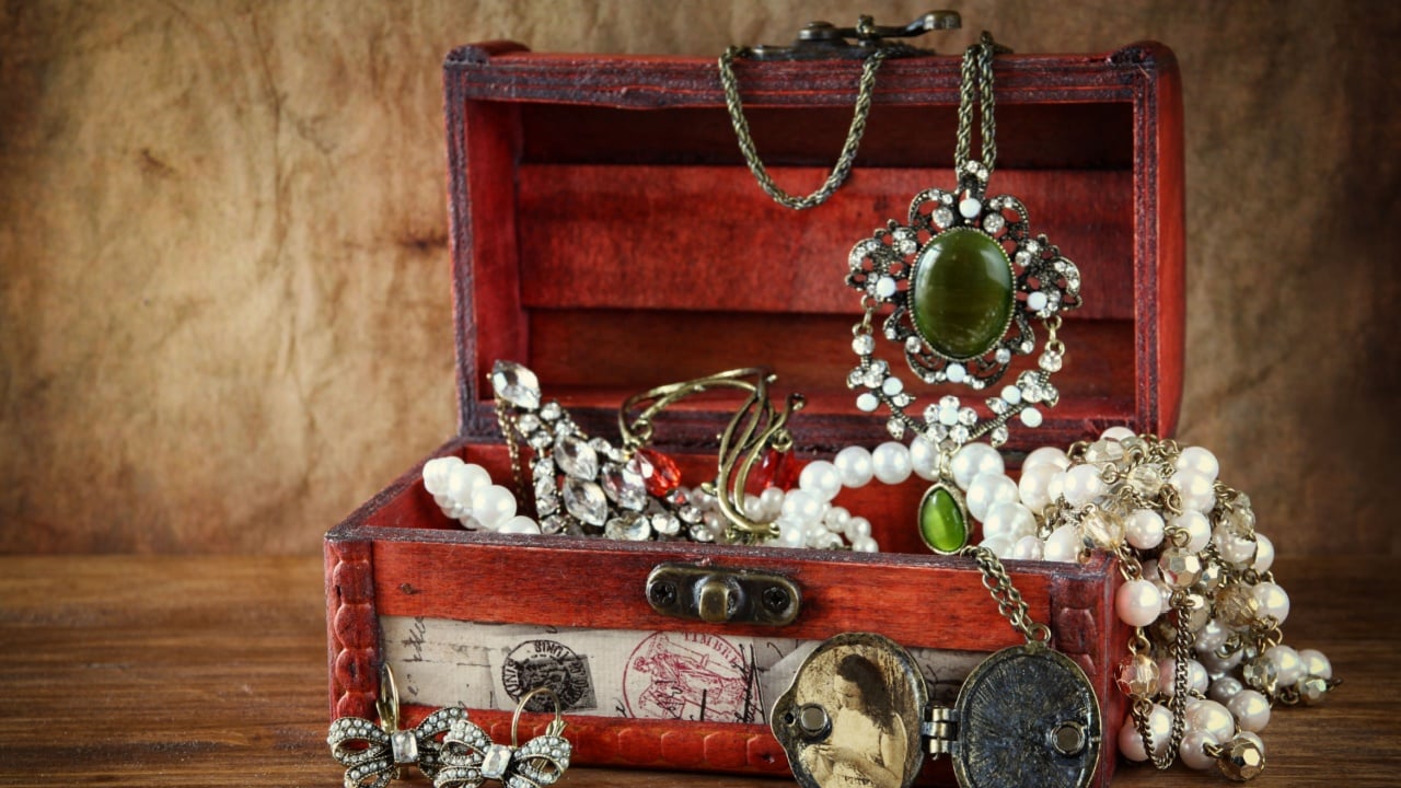A collection of vintage jewelry in antique wooden box