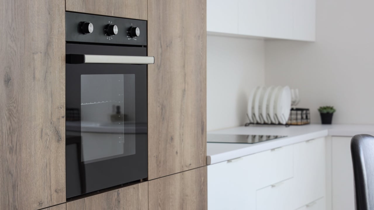 Wooden furniture with modern built-in oven in kitchen