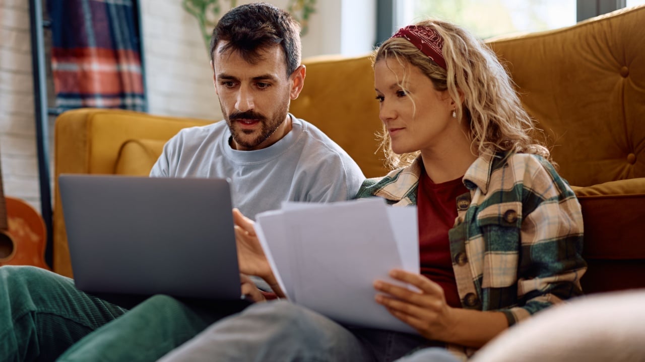 Mid adult couple paying their taxes online at home.