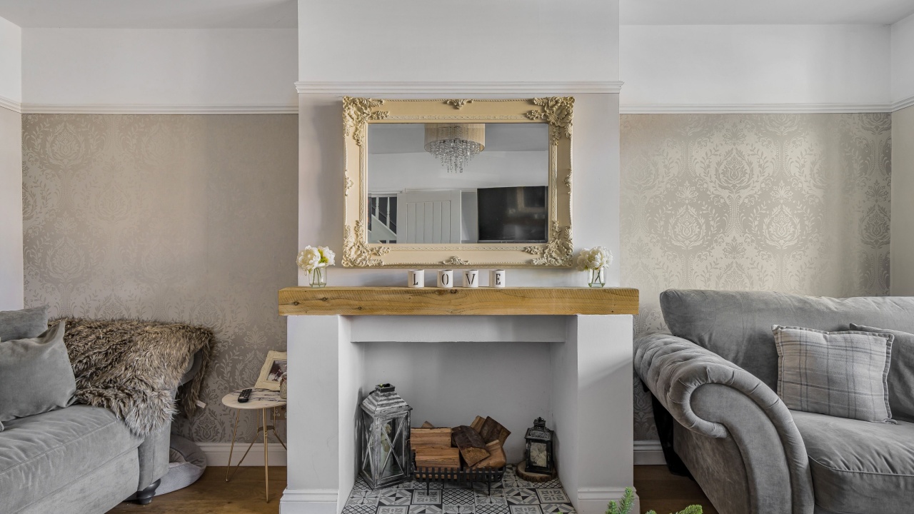A cozy living room with a decorative fireplace and ornate mirror.
