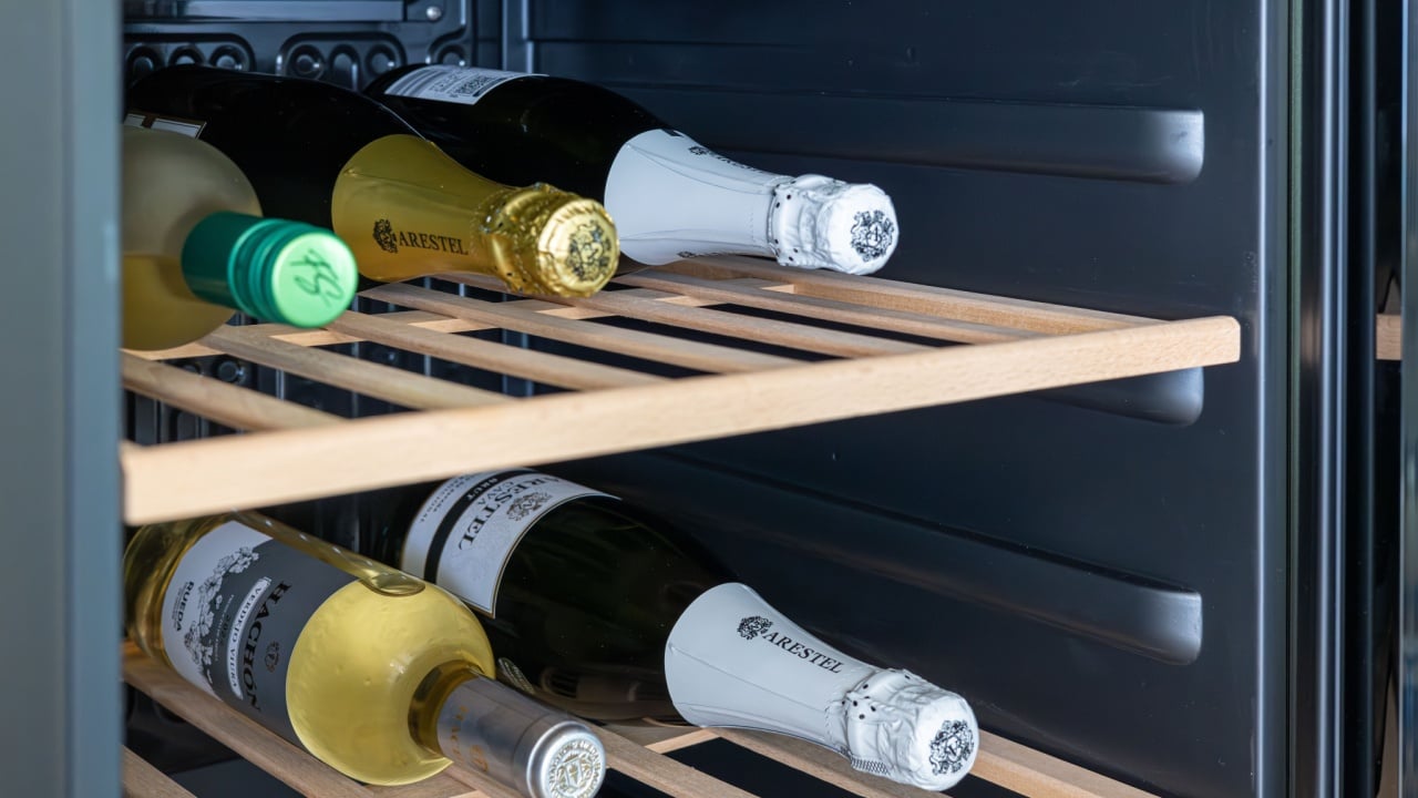 Close-up of wine bottles stored in wine fridge on wooden racks.Torrevieja, Spain 21 June 2025: