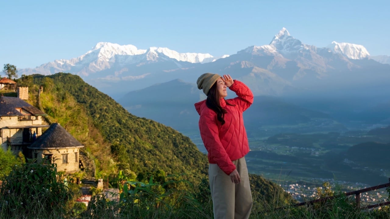 Portrait image of a woman traveler looking at Machapuchare peak, Annapurna mountain range in Sarangkot view point, Pokhara , Nepal