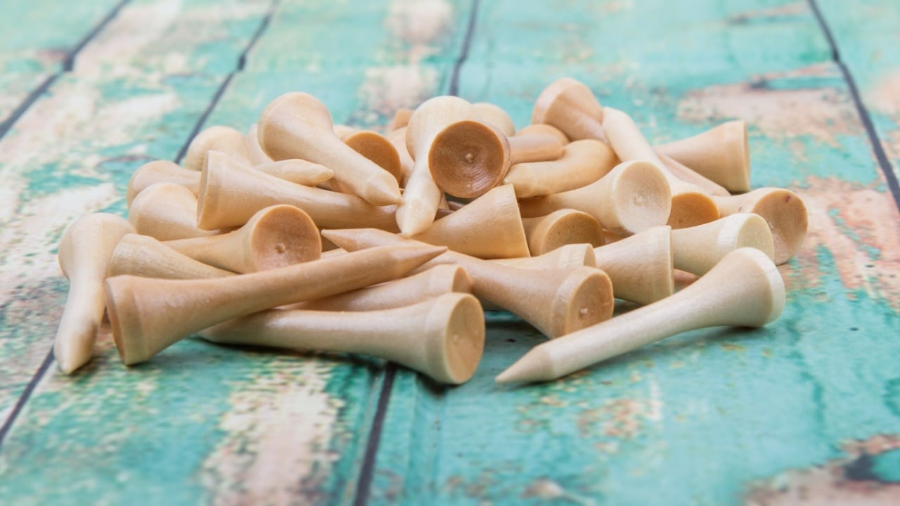 Wood golf tee over wooden background