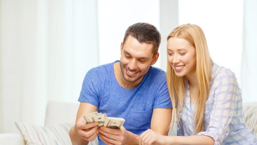 Smiling couple counting money at home