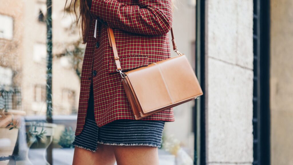 Street style, attractive woman wearing a mini skirt, check plaid blazer and A Shoulder Bag