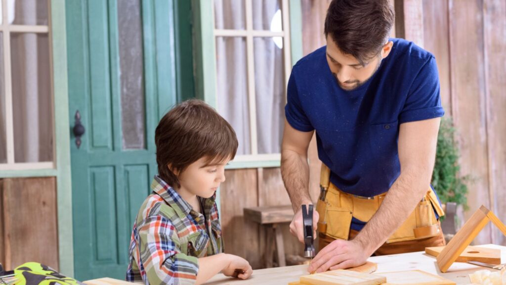 dad and son boy man building with hammer and nail woodwork