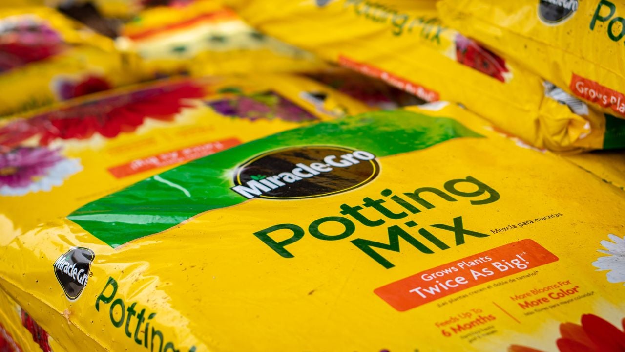 Bags of Miracle Gro potting soil stacked at a feed and seed store ready for the consumer to plant.