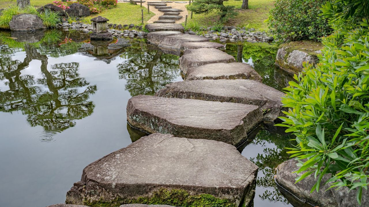 Large flat rocks forming a path over a Japanese pond. Koko-en zen garden near Himeji castle.