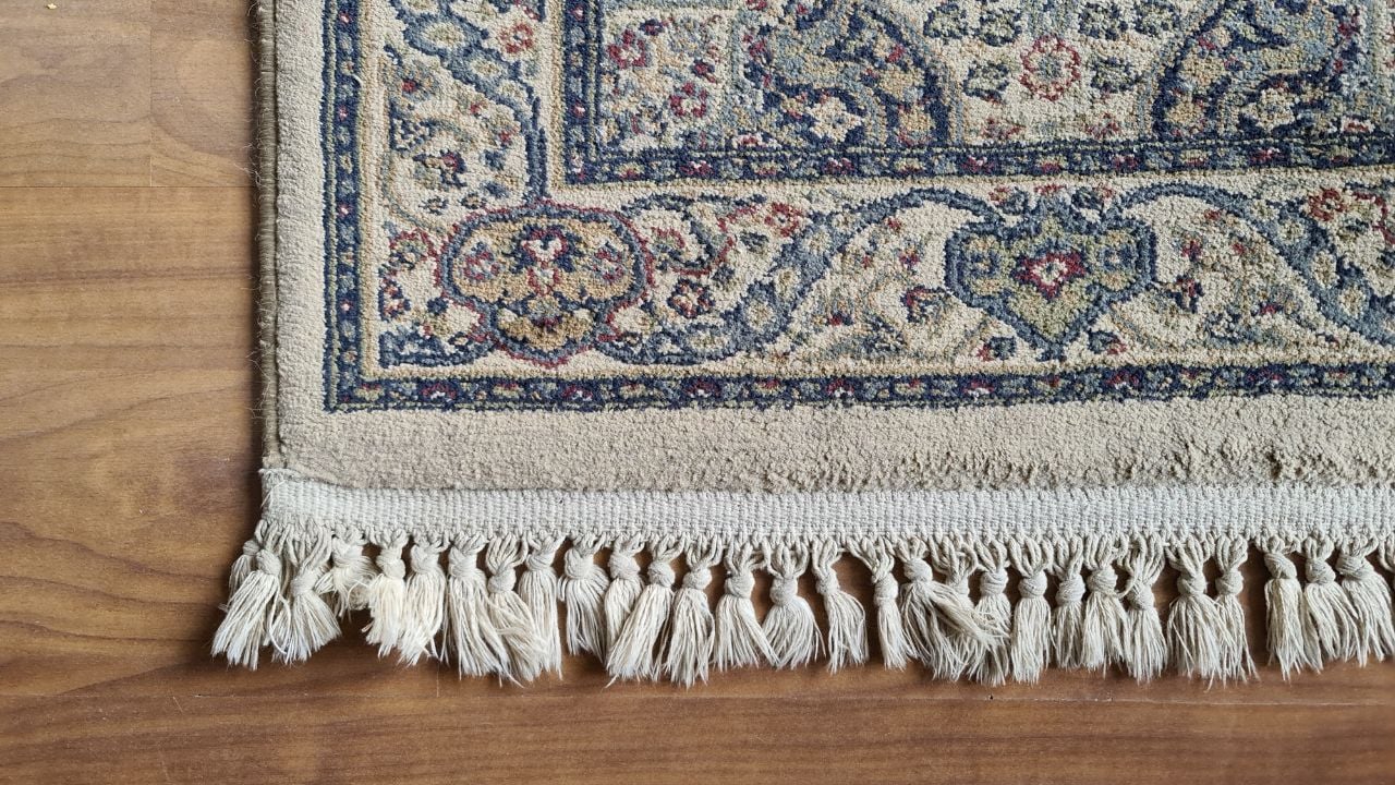 decorative persian rug with cotton fringe on laminated wood flooring