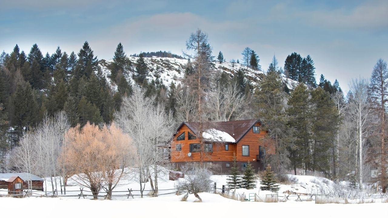 Country homestead cabin with white frozen trees on a cold snowy winter morning in Montana, USA