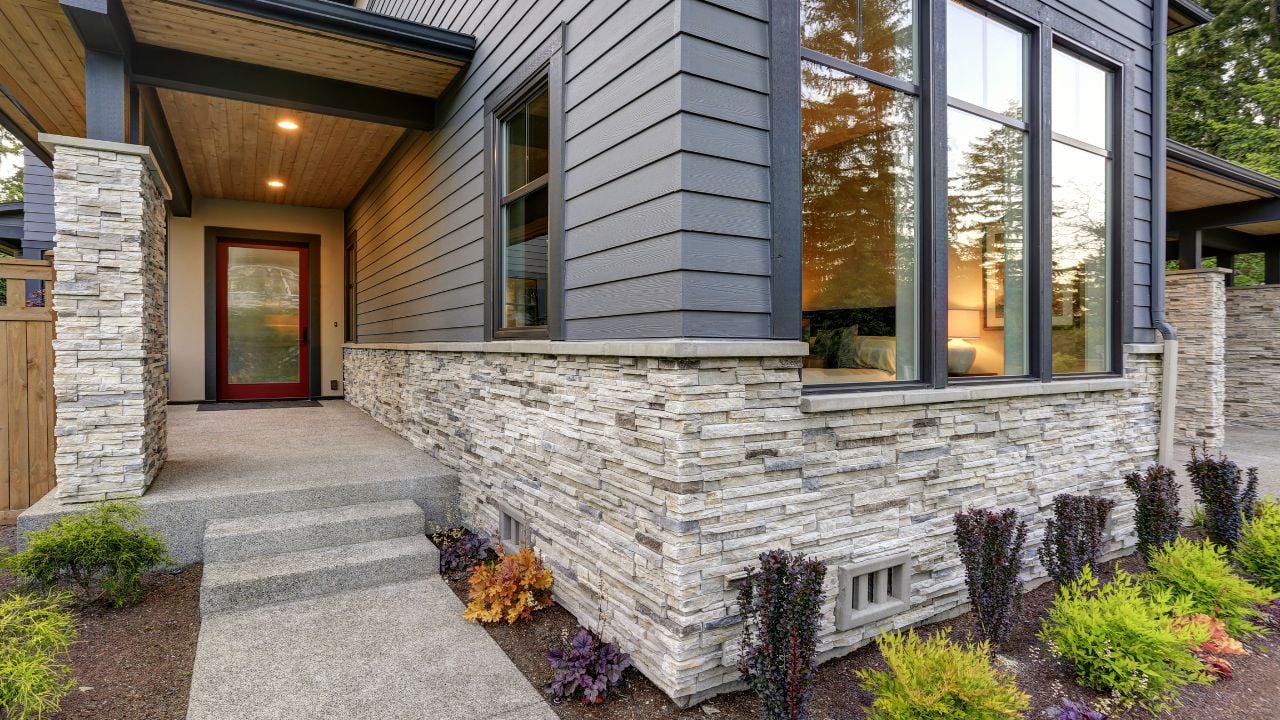 Luxurious new home with curb appeal. Trendy grey two-story exterior in Bellevue with large picture windows, stone siding, covered porch and concrete pathway. Northwest, USA