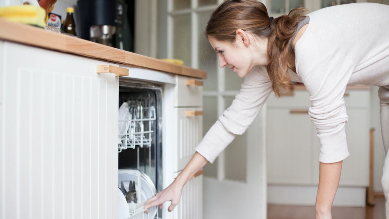woman opening her dishwasher in the kitchen