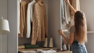 Woman taking warm sweater in wardrobe