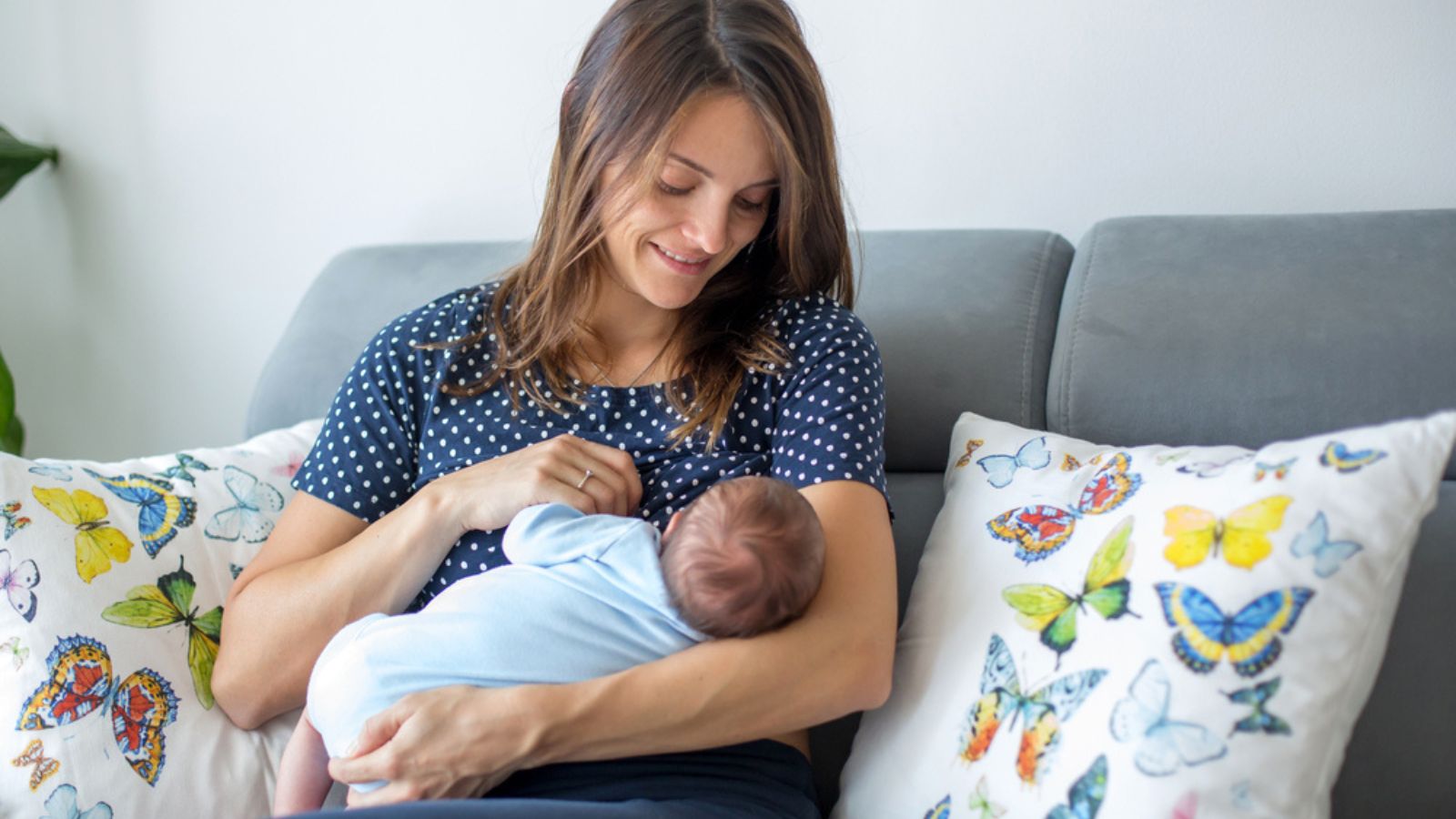Young mother breastfeeding her newborn baby boy