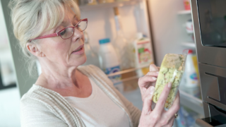 Senior woman checking expiration date on food product